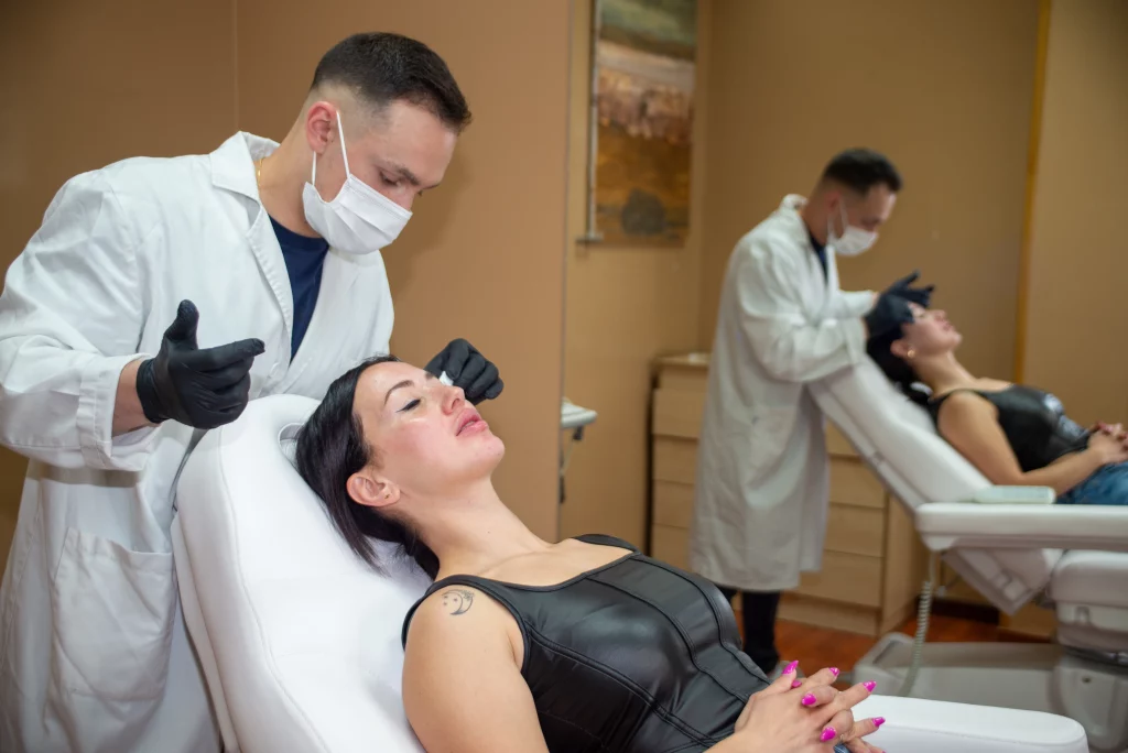 Doctor realizando revisión y moldeado facial después de un tratamiento estético en clínica de Santiago de Compostela