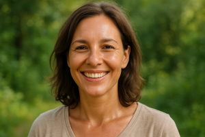 Mujer de 40 años sonriente al aire libre con piel radiante, expresión natural y fondo de naturaleza desenfocado